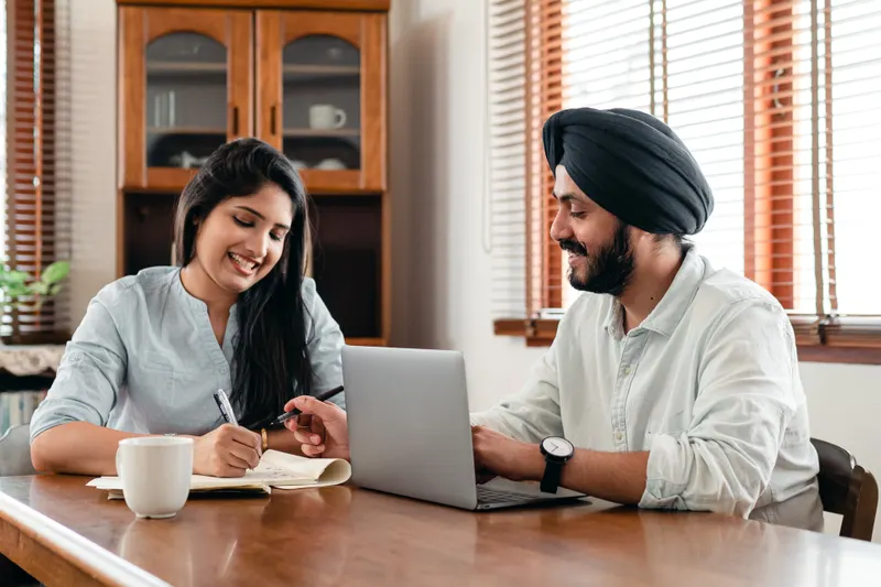 Young professionals working together on a laptop at a Dhaka technology company